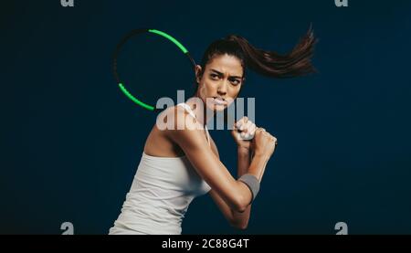 Sportivo con racchetta da tennis. Giocatore di tennis professionista su sfondo scuro. Foto Stock