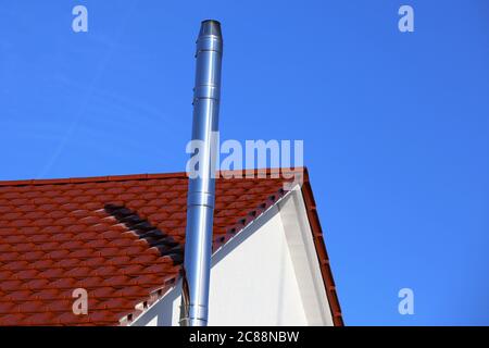 Camino in acciaio inox su una nuova casa residenziale Foto Stock