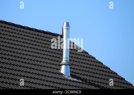 Camino in acciaio inox su una nuova casa residenziale Foto Stock