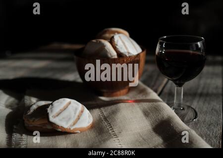 Primo piano di biscotti allo zenzero e un bicchiere di vino su un tavolo di legno Foto Stock