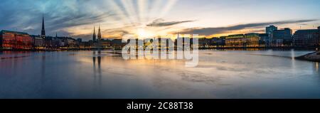 Vista panoramica del lago Alster e del paesaggio urbano di Amburgo, Germania, durante il tramonto contro il cielo drammatico Foto Stock