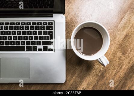 Vista dettagliata di un prodotto noto di un fornitore di computer, visto aperto su una scrivania dei lavoratori di un ufficio domestico mentre il dipendente è lontano dalla scrivania. Foto Stock