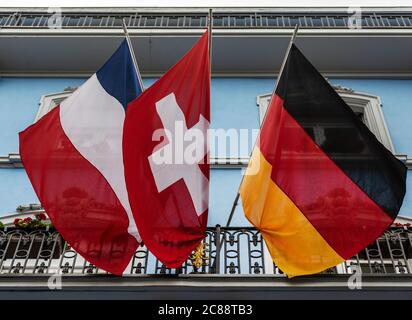 Bandiere francesi, svizzere e tedesche appese al balcone dell'hotel a Basilea Foto Stock