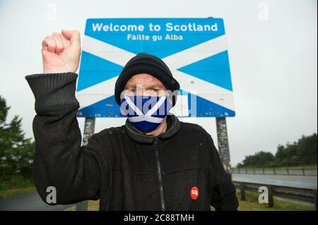 Confine scozzese/inglese a Berwick, Scozia, Regno Unito. 22 luglio 2020 nella foto: Sean Clerkin di azione per la Scozia. Tutti devono smettere di viaggiare dall'Inghilterra alla Scozia per ragioni non essenziali per proteggere la popolazione scozzese dal Covid-19. I nuovi casi di Covid-19 sono 5.5 volte superiori in Inghilterra rispetto alla Scozia e il professor Rowland Kao un biologo matematico all'Università DI EDIMBURGO ha recentemente affermato che se vi è un aumento dei viaggi tra Inghilterra e Scozia è inevitabile che i casi di Covid-19 aumenteranno in Scozia. Credit: Colin Fisher/Alamy Live News. Foto Stock