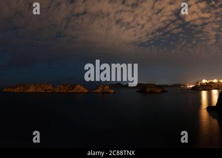 Rocce in mare con un cielo nuvoloso Foto Stock
