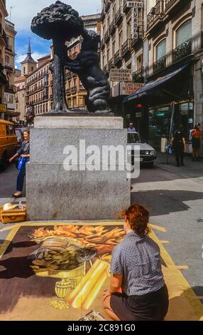 Artista di pavimentazione accanto alla statua dell'orso alla Puerta del Sol di fronte a Carmen Street, Madrid. Spagna. Europa. Circa anni '90 Foto Stock