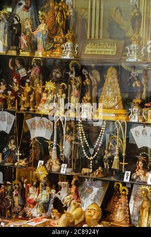 Statue religiose e icone in mostra in una vetrina. Madrid, Spagna Foto Stock