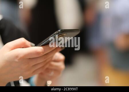 chiudi le mani della donna con lo smartphone. sfondo bokeh Foto Stock