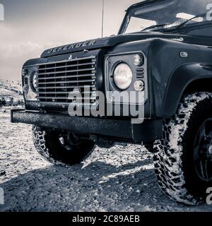 Parte anteriore della Land Rover Defender a trazione integrale con terreno coperto da neve. Foto Stock