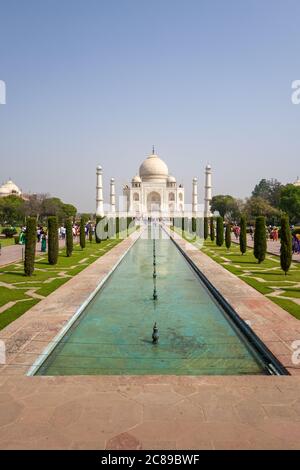 Immagine verticale del Taj Mahal nella soleggiata giornata di aprile, con passaggi pedonali e acqua in primo piano Foto Stock