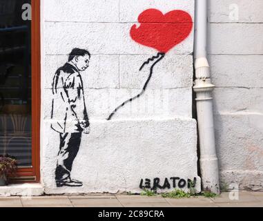 Cracovia. Cracovia. Polonia. Graffiti ispirato dalla famosa Banksy`s 'ragazza con saloon' con Jaroslaw Kaczynski al posto della ragazza dipinta a Kazimierz. Foto Stock