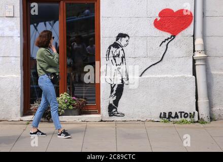 Cracovia. Cracovia. Polonia. Graffiti ispirato dalla famosa Banksy`s 'ragazza con saloon' con Jaroslaw Kaczynski al posto della ragazza dipinta a Kazimierz. Foto Stock