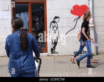 Cracovia. Cracovia. Polonia. Graffiti ispirato dalla famosa Banksy`s 'ragazza con saloon' con Jaroslaw Kaczynski al posto della ragazza dipinta a Kazimierz. Foto Stock