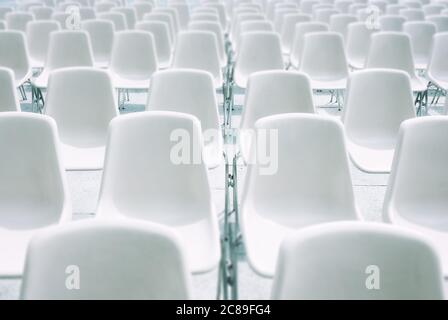 Bancarelle di plastica bianca e sedie in acciaio per eventi all'aperto Foto Stock