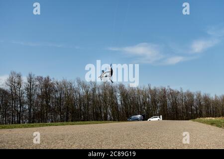 Stötten, Germania - 27 marzo 2020: Vista di un uomo che salta attraverso l'aria, lui pratica il kite sport terra imbarco. Germania. Foto Stock