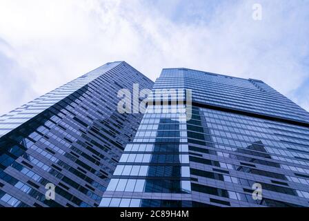 grattacieli in vetro contemporaneo che riflettono gli edifici degli uffici, vista dal basso verso l'alto, tonalità blu Foto Stock