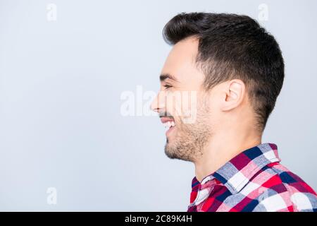 Felice, gioia, divertimento, concetto di gioventù. Profilo laterale ritratto di giovane bell'uomo in camicia casual con sorriso luminoso, vicino spazio di copia Foto Stock