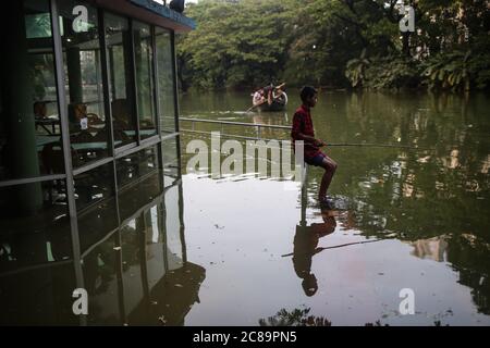 Dhaka, Dhaka, Bangladesh. 22 luglio 2020. Un ragazzo sta pescando nelle acque loggate del lago Dhanmondi lato ristorante.le strade del lago Dhanmondi compreso Rabindra Sarobar sono state allagate a causa di due giorni di piogge continue. Credit: Md. Rakibul Hasan/ZUMA Wire/Alamy Live News Foto Stock