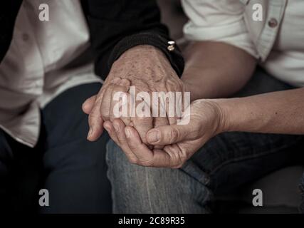 Mani di madre e figlia che tengono insieme nell'amore e nel sostegno dopo che i losing amore ones in mezzo all'epidemia del coronavirus Foto Stock