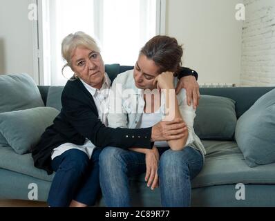 Madre anziana che conforta la figlia adulta che lamenta la perdita di uno amato che combatte il Coronavirus. Madre anziana abbracciando figlia adulta che soffre di de Foto Stock
