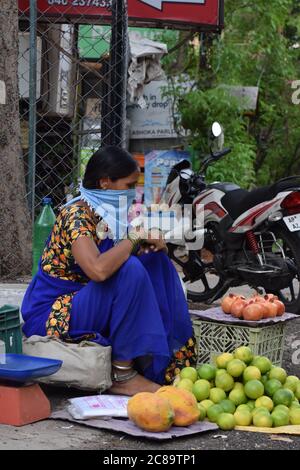 Hyderabad, Telangana, India. luglio-20-2020: Donna, commerciante di frutta stava indossando la maschera nel suo lavoro, donne che vendono i frutti sul lato della strada, piccola impresa Foto Stock