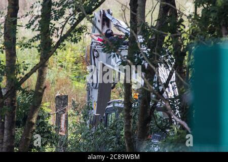 Harefield, Regno Unito. 22 luglio 2020. Un attivista della HS2 Rebellion occupa macchinari pesanti per ritardare la abbattimento degli alberi per HS2 lungo Harvil Road. Diversi attivisti ambientali hanno occupato macchinari e alberi in protesta contro il collegamento ferroviario ad alta velocità, che attualmente è previsto costare £106 miliardi e rimarrà un contributo netto alle emissioni di CO2 durante la sua durata prevista di 120 anni. Credit: Mark Kerrison/Alamy Live News Foto Stock