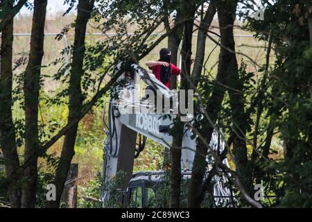 Harefield, Regno Unito. 22 luglio 2020. Un attivista della HS2 Rebellion occupa macchinari pesanti per ritardare la abbattimento degli alberi per HS2 lungo Harvil Road. Diversi attivisti ambientali hanno occupato macchinari e alberi in protesta contro il collegamento ferroviario ad alta velocità, che attualmente è previsto costare £106 miliardi e rimarrà un contributo netto alle emissioni di CO2 durante la sua durata prevista di 120 anni. Credit: Mark Kerrison/Alamy Live News Foto Stock