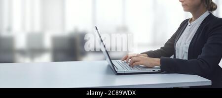 giovane donna d'affari che lavora su un computer portatile in un moderno e luminoso ufficio di lavoro. sfondo aziendale copy space Foto Stock