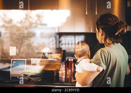 Una donna con un bambino è in piedi in una vecchia casa, California Foto Stock
