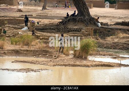 I ragazzi facendo mattoni di fango in un piccolo borgo rurale. Regione di Mopti, Mali, Africa occidentale. Foto Stock