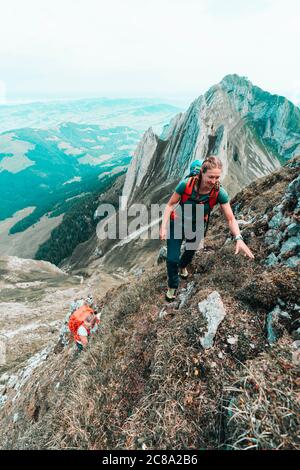 Due donne arrampicatrici che salgono su una montagna ripida in Svizzera Foto Stock