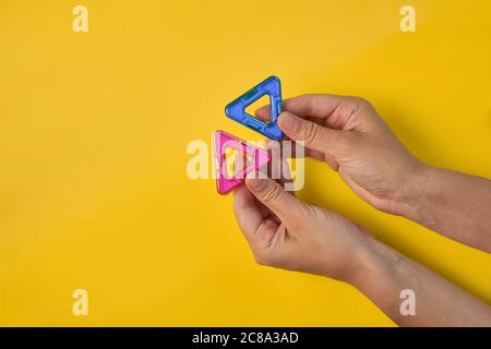 Vista dall'alto di colorati blocchi magnetici su sfondo giallo Foto Stock