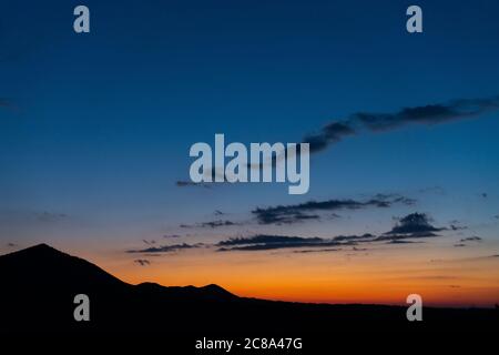 Panorama colorato magnifico tramonto in campagna sopra colline e campi Foto Stock