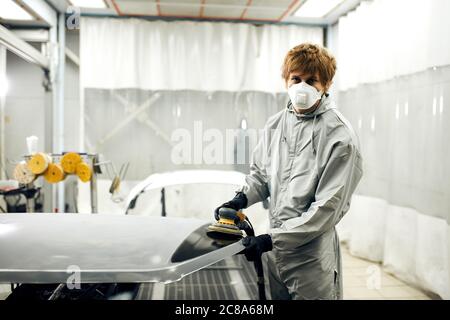 Meccanico automatico di grind auto parte per la verniciatura. Auto lavoro del corpo auto vernice di riparazione dopo incidente Foto Stock