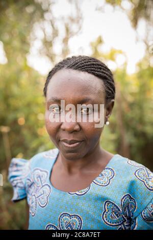 Ritratto di una donna africana con trecce e un vestito blu - Makueni County, Kenya, Africa orientale. Foto Stock