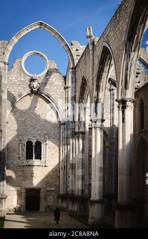 Piccola donna a piedi nelle rovine dell'antico convento di Carmo a Lisbona, Portogallo, chiesa senza tetto aperta al cielo sopravvissuta ai 1755 anni Foto Stock