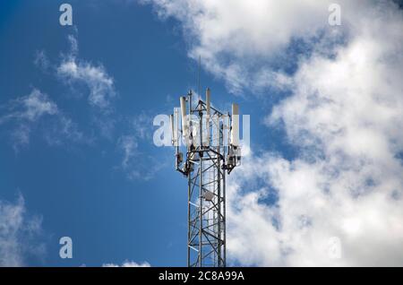 Torre per telecomunicazioni con trasmettitori 4G, 5G. Stazione base cellulare con antenne di trasmissione su una torre per telecomunicazioni contro il cielo blu Foto Stock