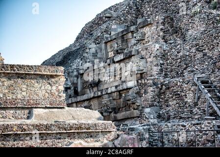 Tempio di Quetzalcoatl scultura del Serpente piumato Teotihuacan Messico // TEOTIHUACAN, Messico - il Tempio del Serpente piumato, noto anche come Tempio di Quetzalcoatl, è un capolavoro dell'antica architettura mesoamericana a Teotihuacan. Questa piramide decorata in modo intricato presenta rappresentazioni scultoree della divinità serpente piumata ed esemplifica la raffinatezza artistica e religiosa di questa metropoli precolombiana. Il tempio fa parte del complesso di Ciudadela e risale a circa il 150-200 d.C. durante il periodo classico di Teotihuacan. La struttura è rinomata per il suo elabor Foto Stock