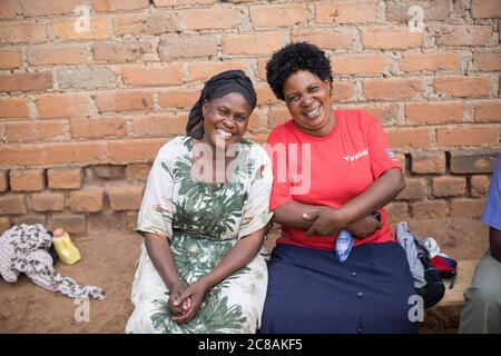 Rose Nabyonga (60, l) e Polly Nayiga (56, r) si siedono insieme ad un incontro di risparmio e prestito del villaggio nel distretto di Kyotera, Uganda. LWR Uganda SEMENTI giovani P Foto Stock