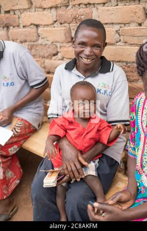 Rose Nawanggi (51) partecipa a un incontro di risparmio e prestito con suo figlio Daniel (12 mesi), nel distretto di Kyotera, Uganda. LWR Uganda Youth SEED Pro Foto Stock