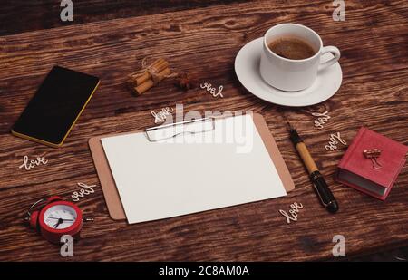 una tazza di caffè, taccuino, penna d'inchiostro, telefono su sfondo di legno Foto Stock