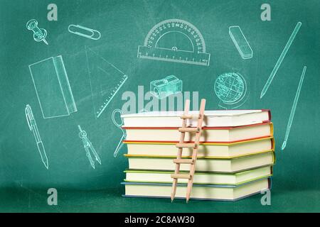 concetto di educazione con scala a matita su pila di libri contro lavagna verde Foto Stock