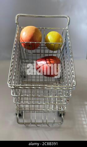 Carrello in miniatura con mele di dimensioni standard e prugna verde Foto Stock