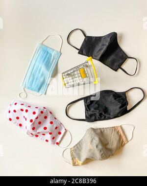 Vista dall'alto del carrello giallo in miniatura tra i vari tipi di maschere protettive Foto Stock