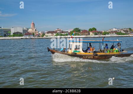 Una barca che trasporta i lavoratori comunali per la manutenzione del fiume che fuma giù il fiume di Chao Phraya a Bangkok, Tailandia Foto Stock