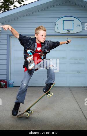 Le acrobazie di skateboard del ragazzo biondo ti lasceranno stupire Foto Stock