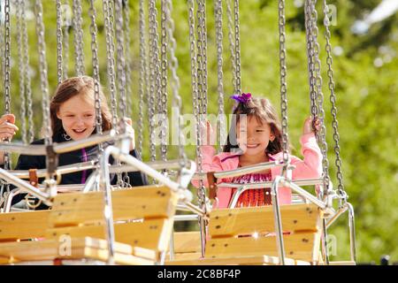 I bambini si divertono a fare un giro in giostra durante un pomeriggio di sole all'Heritage Park di Calgary Alberta Foto Stock