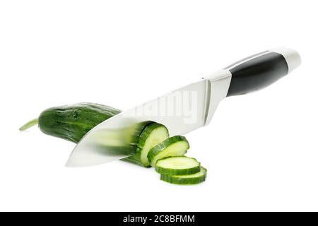coltello da chef che affina un cetriolo su bianco Foto Stock