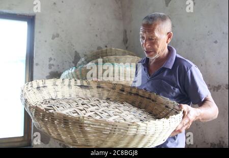 23 luglio 2020, Haian, Haian, Cina: JiangsuÃ¯Â¼Å-CINA tradizionale bambù tessitura in Hai 'an città, Jiangsu Provincia, deve essere intessuto in vari tipi di cestini di bambù, STUOIE, setacci e altri prodotti di meet-making attraverso vari processi come la selezione di bambù, la separazione, raschiatura, e tessitura. A causa dei prodotti ecologici e di protezione ambientale, sempre più da parte dei cittadini urbani e rurali Love.At l'età di 14 anni, Jingbu Yin di Shuangxi Village, Duntou Town, città di Haian, provincia di Jiangsu, ha imparato ad essere un artigiano di bambù al suggestivo del padre.He sta facendo questo traditi Foto Stock