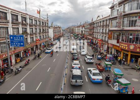 Lhasa, Tibet / Cina - 29 luglio 2017: Vista sulla strada principale di Lhasa (Beijing East Road) - con traffico confettura. Tradizionali case tibetane sulla sinistra e RIG Foto Stock